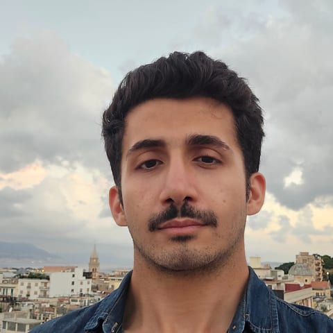 Matin Azad Milani su una terrazza a Messina, con lo Stretto alle spalle